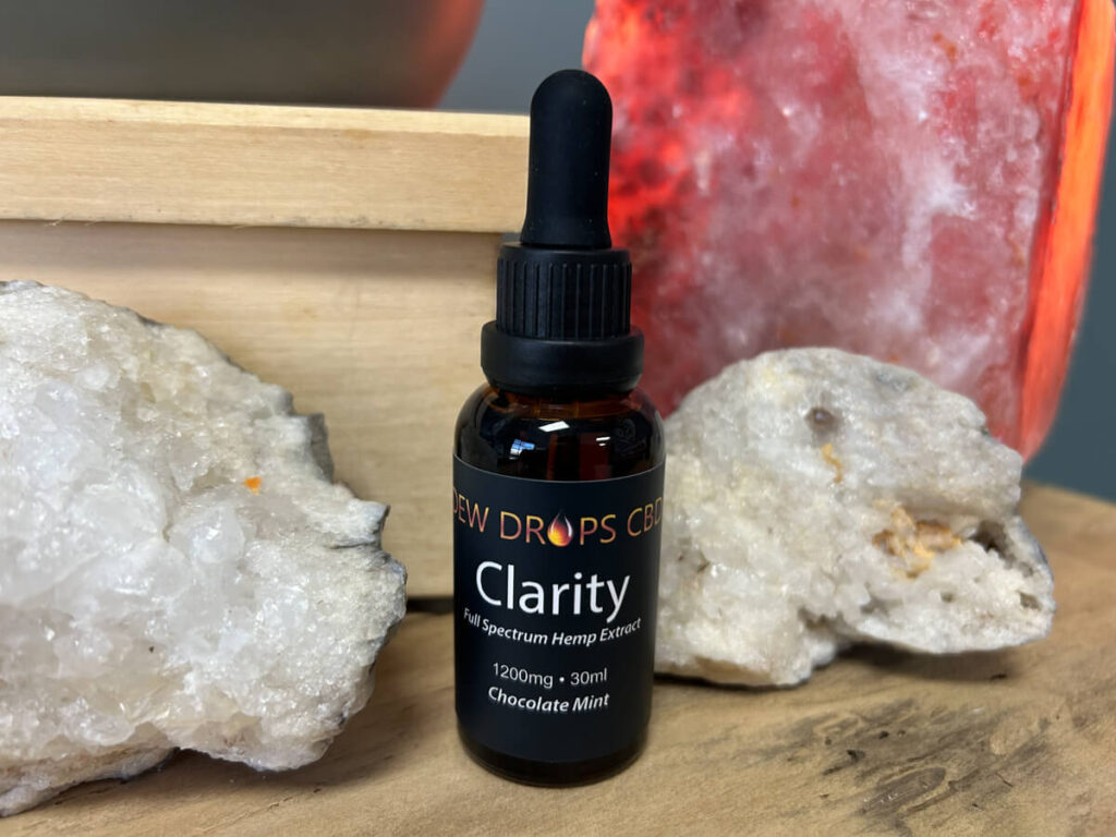 A bottle of clarity is sitting on some rocks.